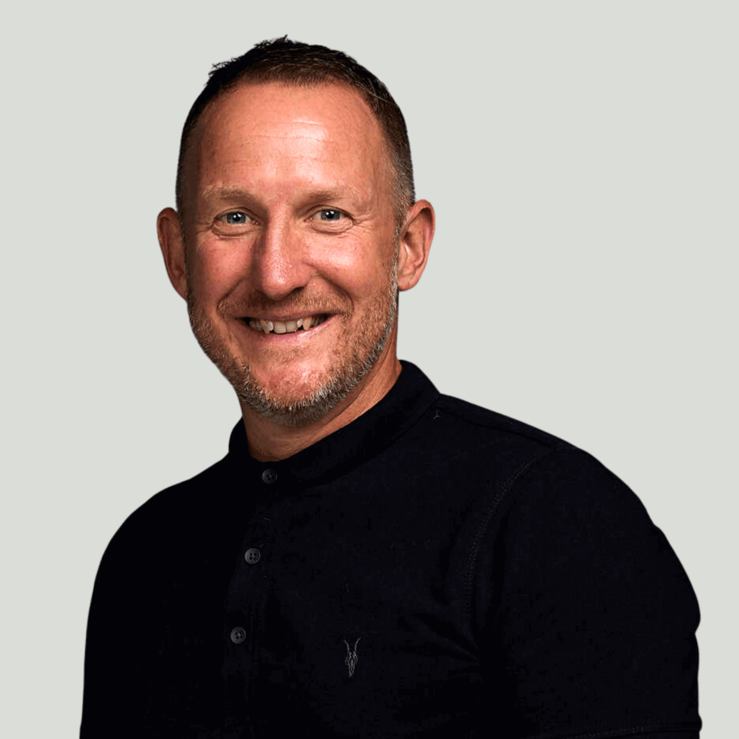 Photo of a middle-aged man smiling and wearing a black top